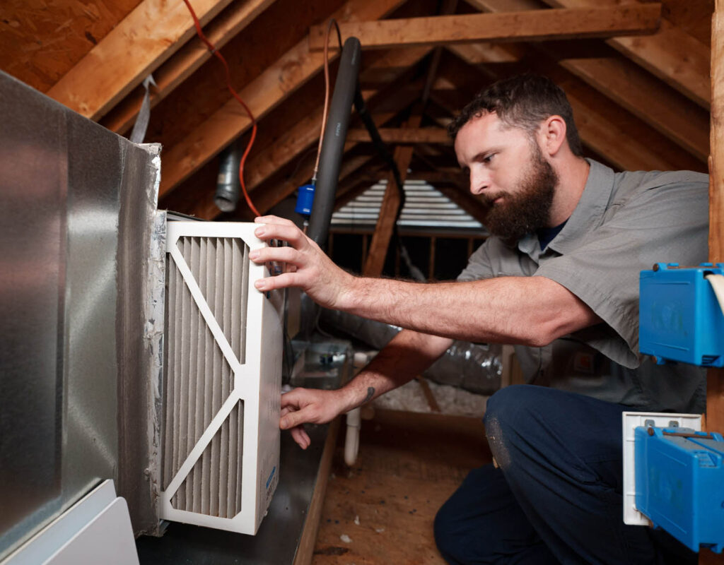 a-technician-installing-a-unit-in-the-attic-of-a-home