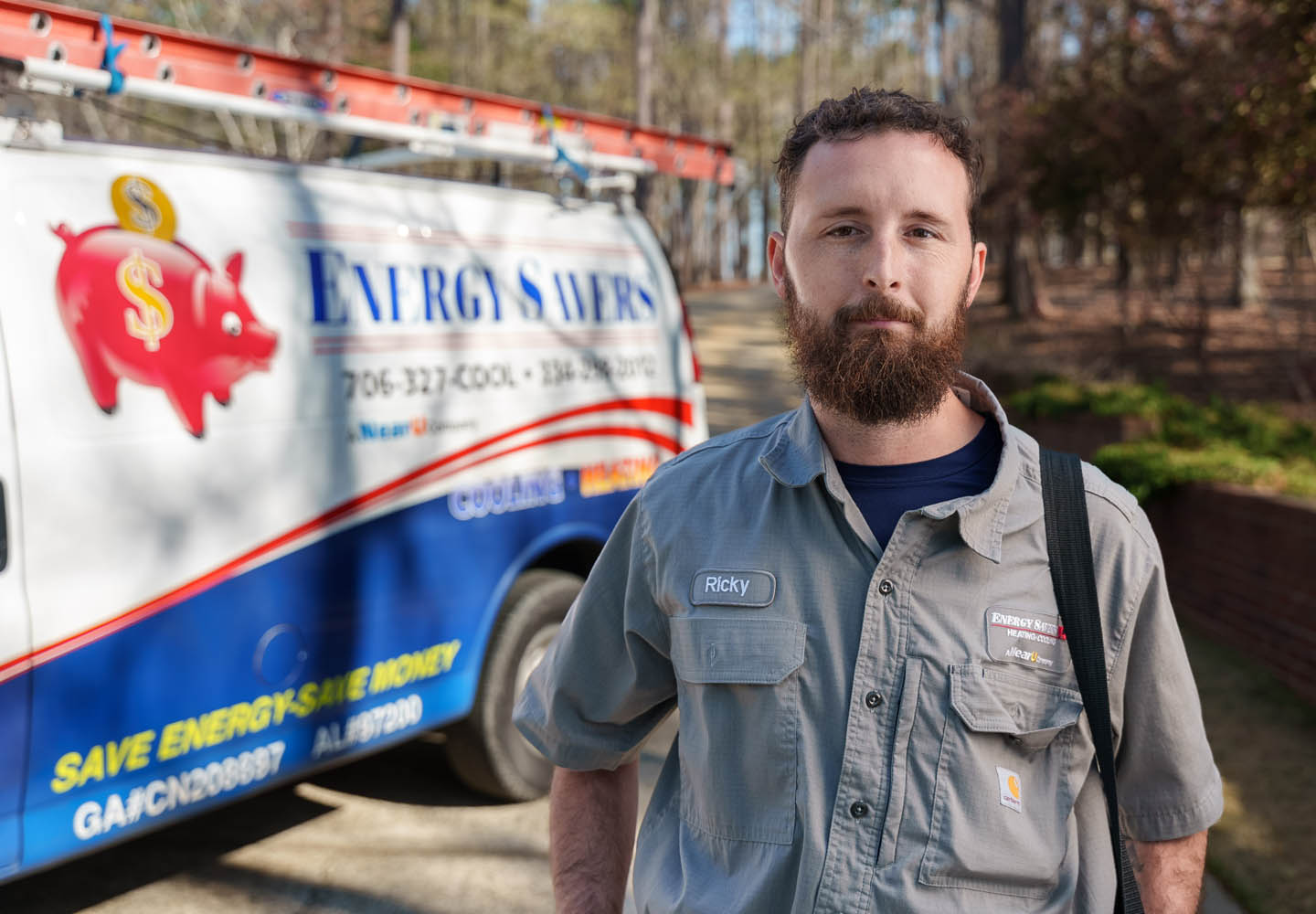 An Energy Savers technician standing in front of a service truck
